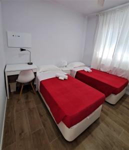two beds in a room with a desk and a desk at Sant Jordi Pisos - Dos de Maig in Barcelona