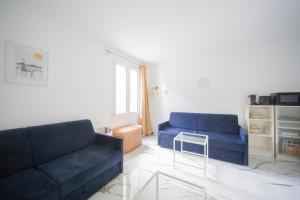 ein Wohnzimmer mit zwei blauen Sofas und einem Tisch in der Unterkunft Studio - Luxury Home in Bussy-Saint-Georges