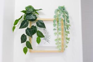 ein Holzrahmen mit grünen Pflanzen an einer Wand in der Unterkunft Studio - Luxury Home in Bussy-Saint-Georges