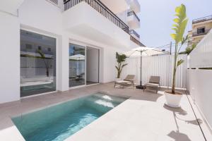 basen na podwórku domu w obiekcie Bossa Bay Suites with Private Pool - MC Apartments Ibiza w mieście Ibiza