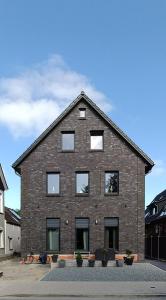 um grande edifício de tijolos com janelas numa rua em Moderne Ferienwohnung direkt am Kanal / Neubau em Emden