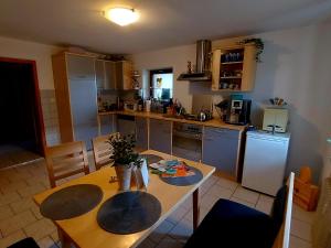 a kitchen with a wooden table and a table and chairs at Über den Dächern von Furth im Wald in Furth im Wald