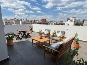 un patio con sillas y una mesa en el techo en Baja California 279 Apartments, en Ciudad de México