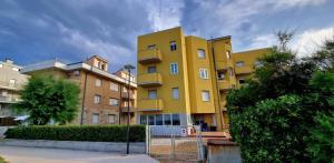 a yellow building with a fence in front of it at Casa Chicchina in Senigallia