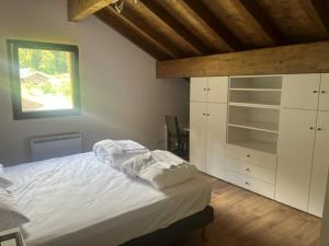 1 dormitorio con cama blanca y ventana en Luxurious new villa in the Alpes with sauna and jacuzzi en Bellevaux