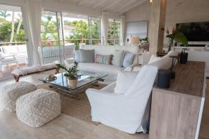 a living room with a white couch and chairs at Family-Friendly 4-Bedroom Golf Villa with Private Pool, Jacuzzi, and Golf Cart in La Romana