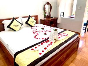 Un dormitorio con una cama con flores rojas. en Minh Khoi Guest House, en Mui Ne