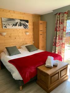 a bedroom with a large bed with a red blanket at Hotel Le Concorde in Morzine