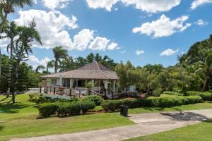 una casa en un parque con palmeras en Family-Friendly 4-Bedroom Golf Villa with Private Pool, Jacuzzi, and Golf Cart, en La Romana