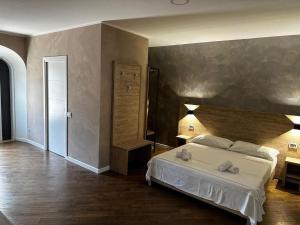 蒙特-坡佐-卡多的住宿－Casa Catone (affitta camere)，一间卧室设有一张床和一个大墙