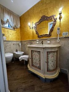 Casa Catone (affitta camere) في مونتي بورزيو كاتوني: حمام مع حوض ومرآة على الحائط