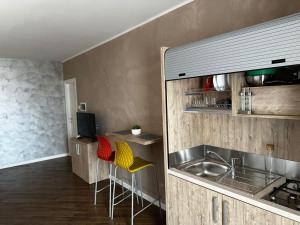 a kitchen with a sink and a counter with stools at Casa Catone (affitta camere) in Monte Porzio Catone
