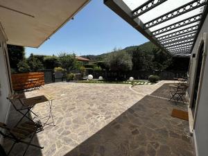 un patio con sillas y toldo en una casa en Casa Catone (affitta camere), en Monte Porzio Catone