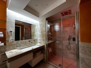 y baño con ducha, lavabo y espejo. en Casa Catone (affitta camere), en Monte Porzio Catone