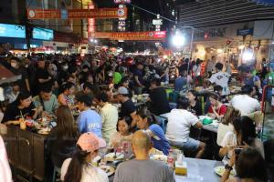 une foule de personnes assises à des tables mangeant dans une rue bondée dans l'établissement X The Character Yaowarat เดอะคาแลตเตอร์ เยาวราช, à Khlong San