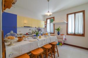 eine Küche mit einem langen Tisch mit Hockern in der Unterkunft Casa Cervade in Palazzo Del Maino