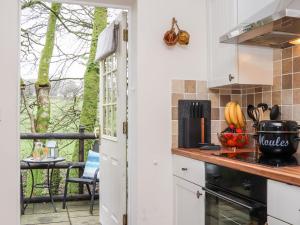 a kitchen with a view of a patio at Inny Brook Cottage in Camelford