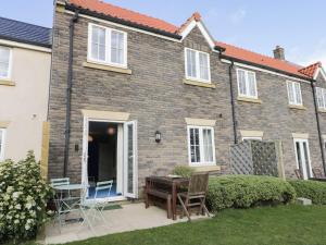 a house with a table and chairs in the yard at The Beach Retreat in Filey