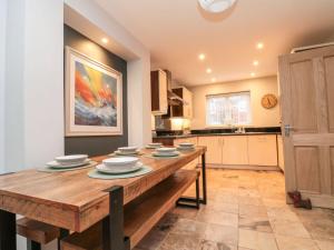 a kitchen with a wooden table with plates on it at The Beach Retreat in Filey