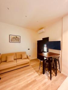 ein Wohnzimmer mit einem Sofa und einem Tisch in der Unterkunft Apartamentos Sunsets Málaga Centro in Málaga