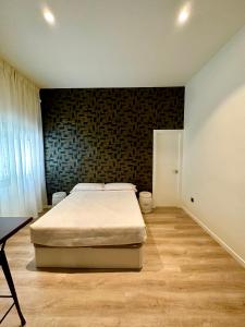 ein Schlafzimmer mit einem Bett und einer Ziegelwand in der Unterkunft Apartamentos Sunsets Málaga Centro in Málaga