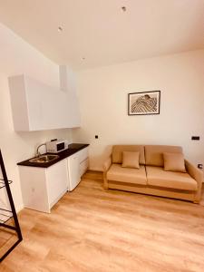 ein Wohnzimmer mit einem Sofa und einer Küche in der Unterkunft Apartamentos Sunsets Málaga Centro in Málaga