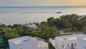 an aerial view of two white houses and the ocean at serene villas in Ierápetra