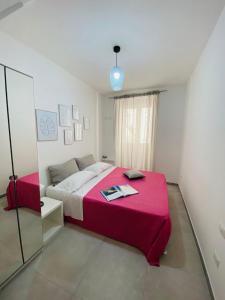 a bedroom with a large bed with a pink blanket at Casa 68 Ortigia in Siracusa