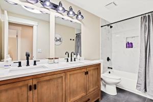 a bathroom with a sink and a toilet and a mirror at Stunning Golf Course Retreat 4BR Home in Eagle