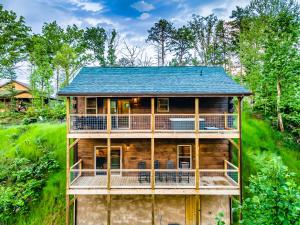 a log home with a blue roof at Modern Mountain Cabin! Hot Tub! Near Downtown! in Gatlinburg