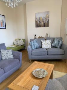 a living room with two couches and a coffee table at Postman's Knock, Lynmouth, first floor apartment with private parking in Lynmouth