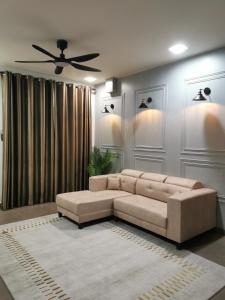 a living room with a couch and a ceiling fan at NK HOMESTAY DESARU in Bandar Penawar