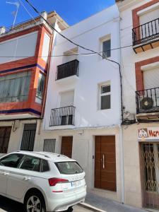 Un coche blanco aparcado delante de un edificio en Apartamento del Agua, en Rute