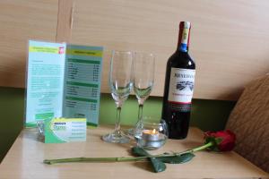 a bottle of wine and two wine glasses on a table at Hostal Terra 2 - EL CONDADO in Quito