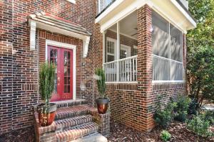 a brick house with a red door and potted plants at The Home Collection CLT: Kirkwood Avenue in Charlotte
