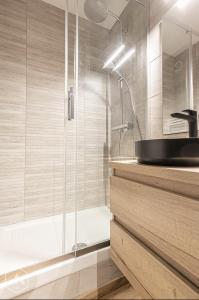 La salle de bains est pourvue d'un lavabo et d'une douche. dans l'établissement La Norma en Terrasse, à Villarodin-Bourget
