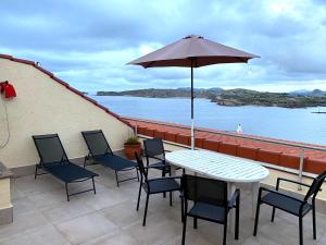 a patio with a table and chairs and an umbrella at Playa de los Locos con Garaje Recién Reformado!! in Suances