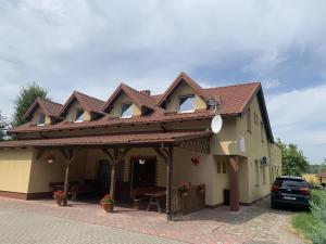 a house with awning and a table and chairs at Noclegi Ciesiul in Orneta