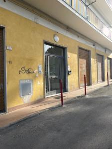 un edificio giallo con graffiti sul lato di ST APARTMENT - DI FRONTE AL TRIBUNALE di Nocera a Nocera Inferiore