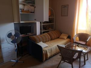 sala de estar con sofá, mesa y ventilador en Deliziosa Porzione di Casale, en Pescia Romana