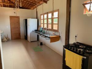 a kitchen with a white refrigerator and a counter at La Paz Village Atins in Atins