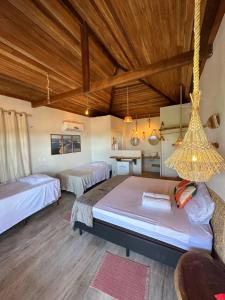 a bedroom with two beds and a wooden ceiling at La Paz Village Atins in Atins
