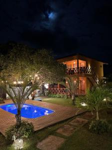 a house with a swimming pool at night at La Paz Village Atins in Atins