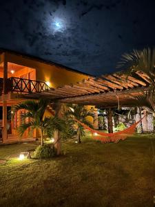 a house with a hammock in front of it at night at La Paz Village Atins in Atins