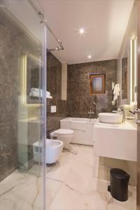a bathroom with two sinks a toilet and a shower at Luxury Villa Flower in Budva