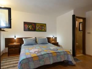 um quarto com uma cama e duas mesas de cabeceira e uma televisão em Villa Rošin with Garden&Pool em Milna