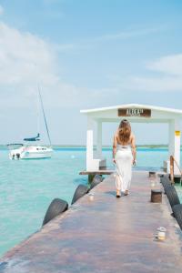 a woman walking on a dock near the water at Hotel Aldea 19 Bacalar in Bacalar