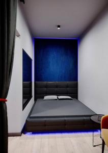 een slaapkamer met een bed met een blauwe muur bij Relax Mini Hotel Jindřišská in Praag