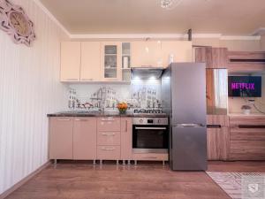  La cuisine est équipée de placards blancs et d'un réfrigérateur. dans l'établissement RentHouse Apartments Little Paris, à Chişinău