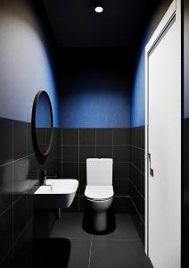 een badkamer met een toilet, een wastafel en een spiegel bij Relax Mini Hotel Jindřišská in Praag